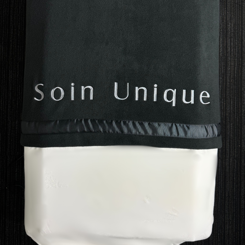 Couverture n polar brodée soin unique sur table de massage avec drap blanc